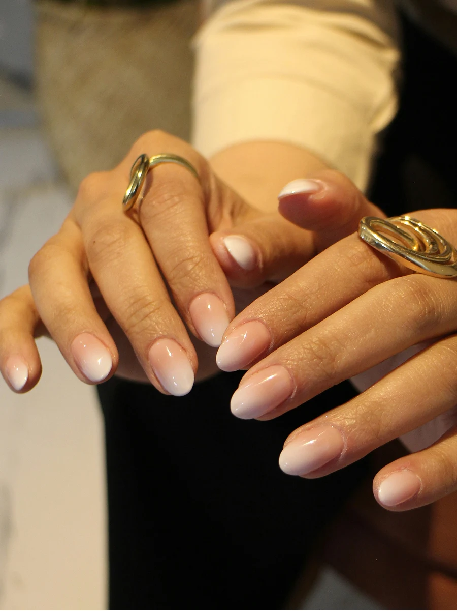 Κοντινό πλάνο ενός ombre shellac μανικιούρ μιας πελάτισσας σε κλασικές nude αποχρώσεις, αμέσως μετά το μανικιούρ της στο salon