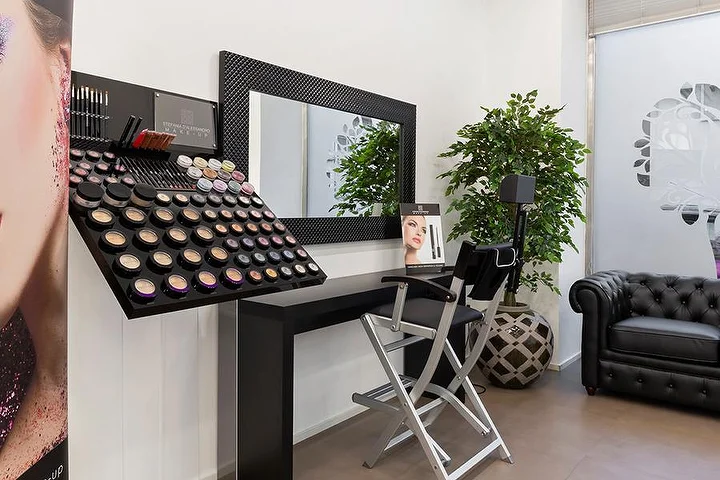 Φωτεινό σαλόνι μανικιούρ Top Estetica στη Villanova, Cagliari, με τοίχο σε χρώμα τυρκουάζ, ανθισμένα γραφεία και μαρμάρινα δάπεδα.